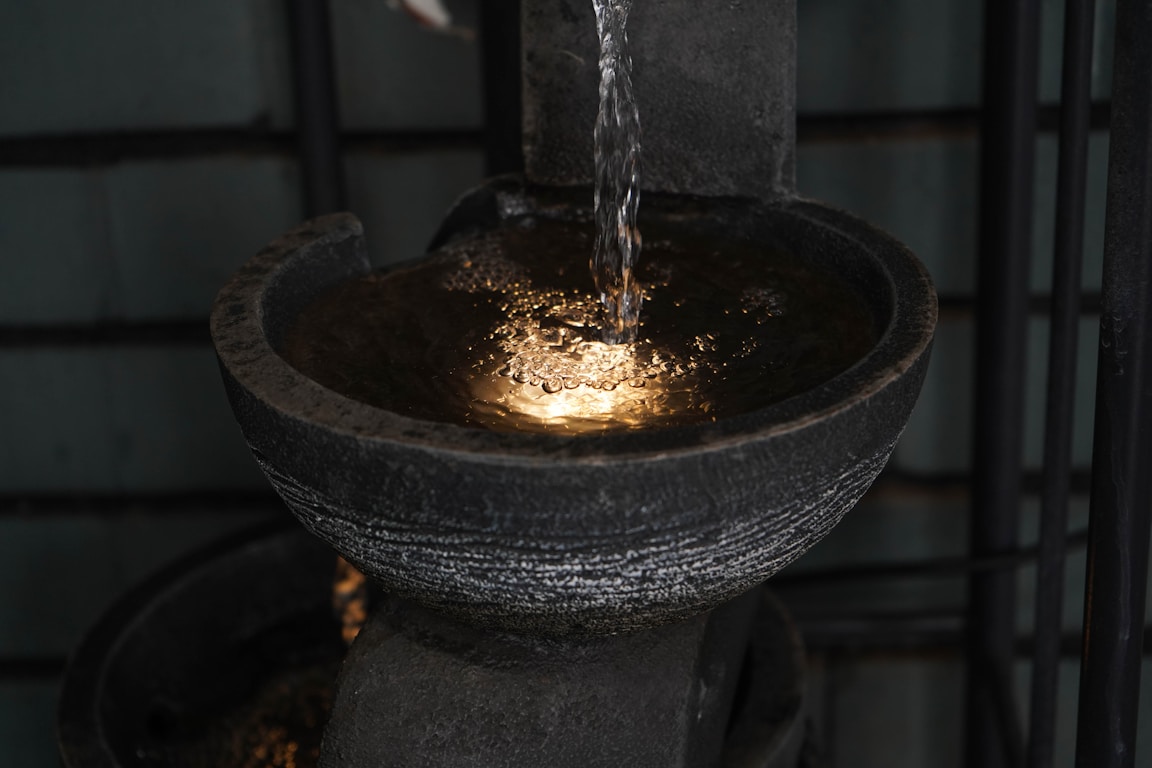 A stream of water pouring into a glowing stone basin.