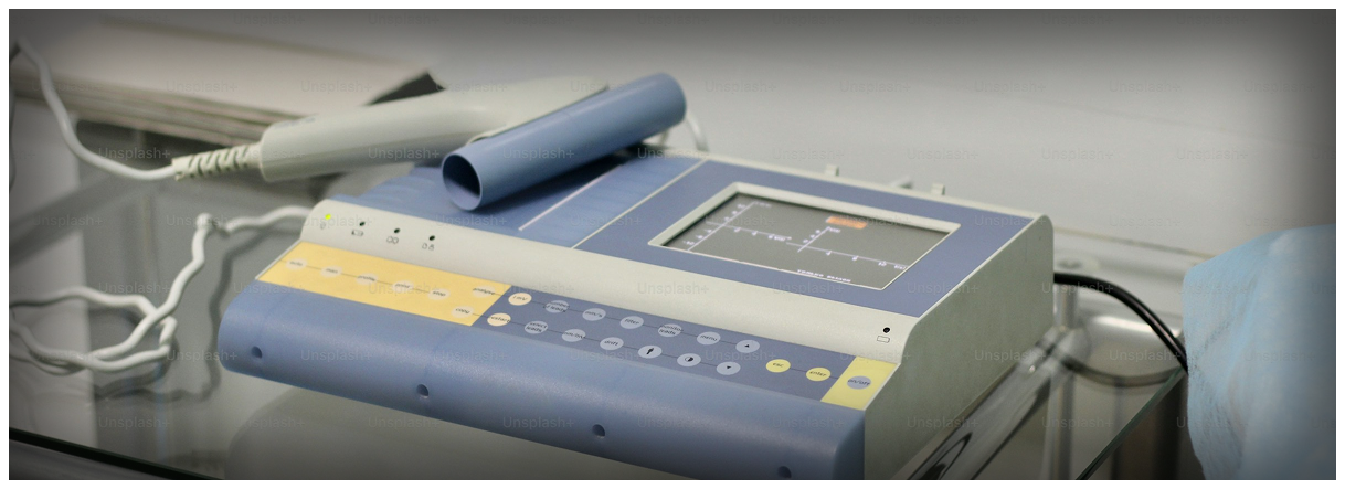 A BTL-08 MT Plus ECG machine with its color touch screen display showing a waveform, sitting on a glass-topped medical cart.